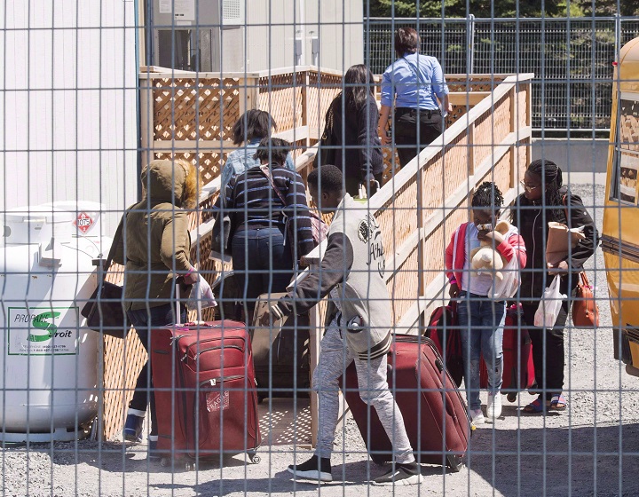 A group of asylum seekers arrive at the temporary housing facilities at the border crossing on Wednesday, May 9, 2018, in St. Bernard-de-Lacolle, Quebec.