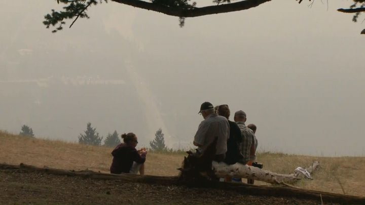 A family visiting Banff eats lunch while taking in a smoke-filled view Wednesday.