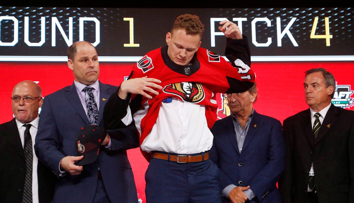 Brady Tkachuk puts on an Ottawa Senators jersey after being selected by the team during the NHL hockey draft in Dallas on June 22, 2018. The Senators have signed the 18-year-old St. Louis native to a three-year, entry-level contract.