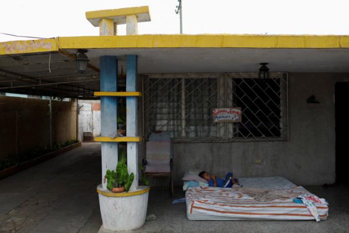 Ismael, son of Cindy Morales, lays down in a mattress at the porch of their home during a blackout in Maracaibo, July 25, 2018.