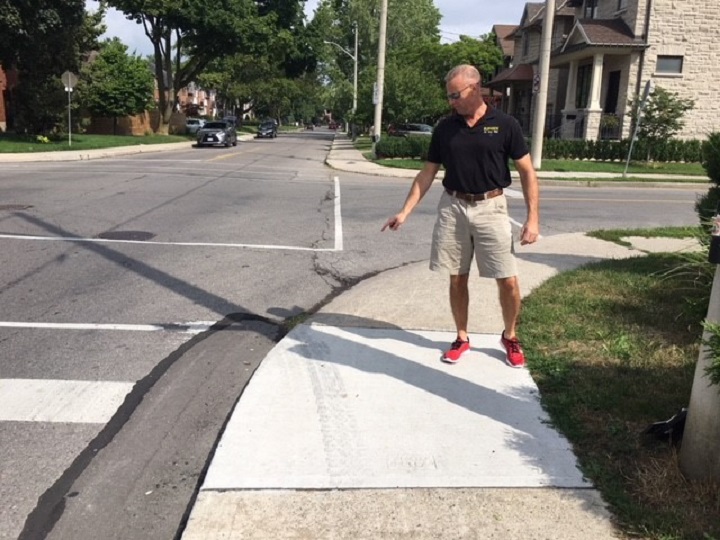Toronto city councillor, Jon Burnside, points to skid marks on the road he says were left by an impaired driver. 