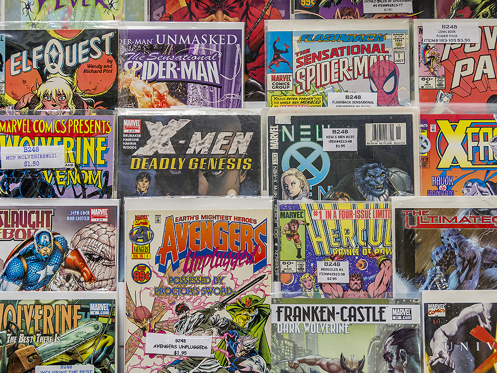 A rack of comic books for sale at a flea market.