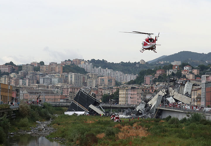 A rescue helicopter flies over the collapsed Morandi Bridge in the Italian port city of Genoa, August 14, 2018.