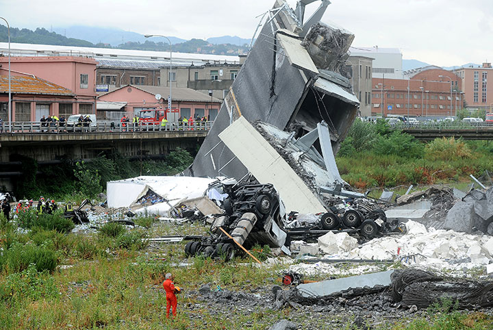 Rescue workers are seen at the collapsed Morandi Bridge in the Italian port city of Genoa, August 14, 2018.
