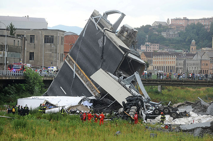 Rescue workers are seen at the collapsed Morandi Bridge in the Italian port city of Genoa, August 14, 2018.