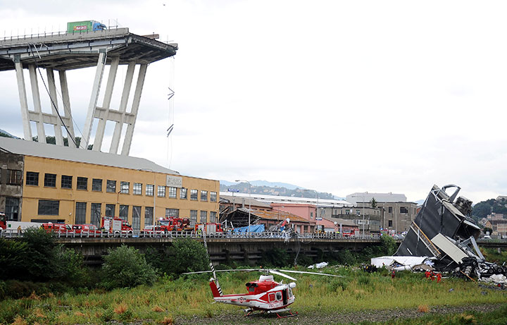 Rescue workers are seen at the collapsed Morandi Bridge in the Italian port city of Genoa, August 14, 2018.