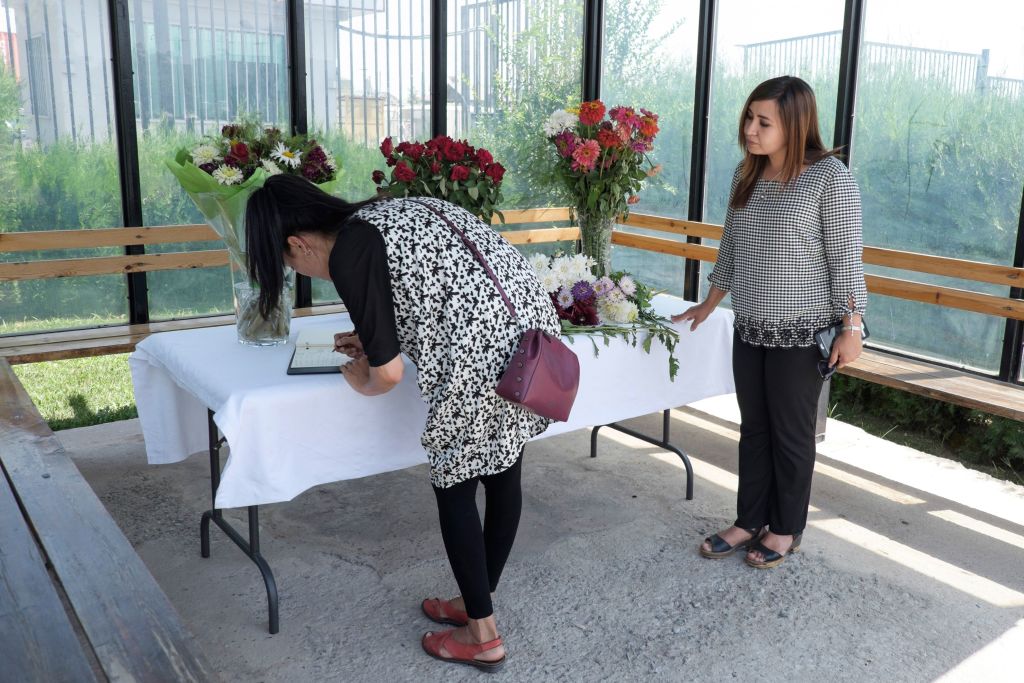 Two women lay flowers and sign a book of condolences at the U.S. Embassy in Dushanbe on July 31, 2018, in tribute to the victims of a deadly attack. Two Americans, along with a Swiss and a Dutch national, were struck by a car and attacked on July 29 while on a popular cycling route in the Danghara district, about 100 kilometres (60 miles) south of the capital Dushanbe.