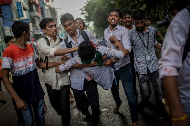 Students help a youth with an eye injury as pro-government activists threw stones and attacked them violently in Dhaka, Bangladesh, Aug. 4, 2018.