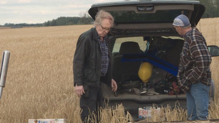 Daniel Jacobs (left) returned to a a wheat field northeast of Edmonton with his brother Larry Jacobs (right) on Monday to recover the helicopter Daniel was in that crashed over the weekend.