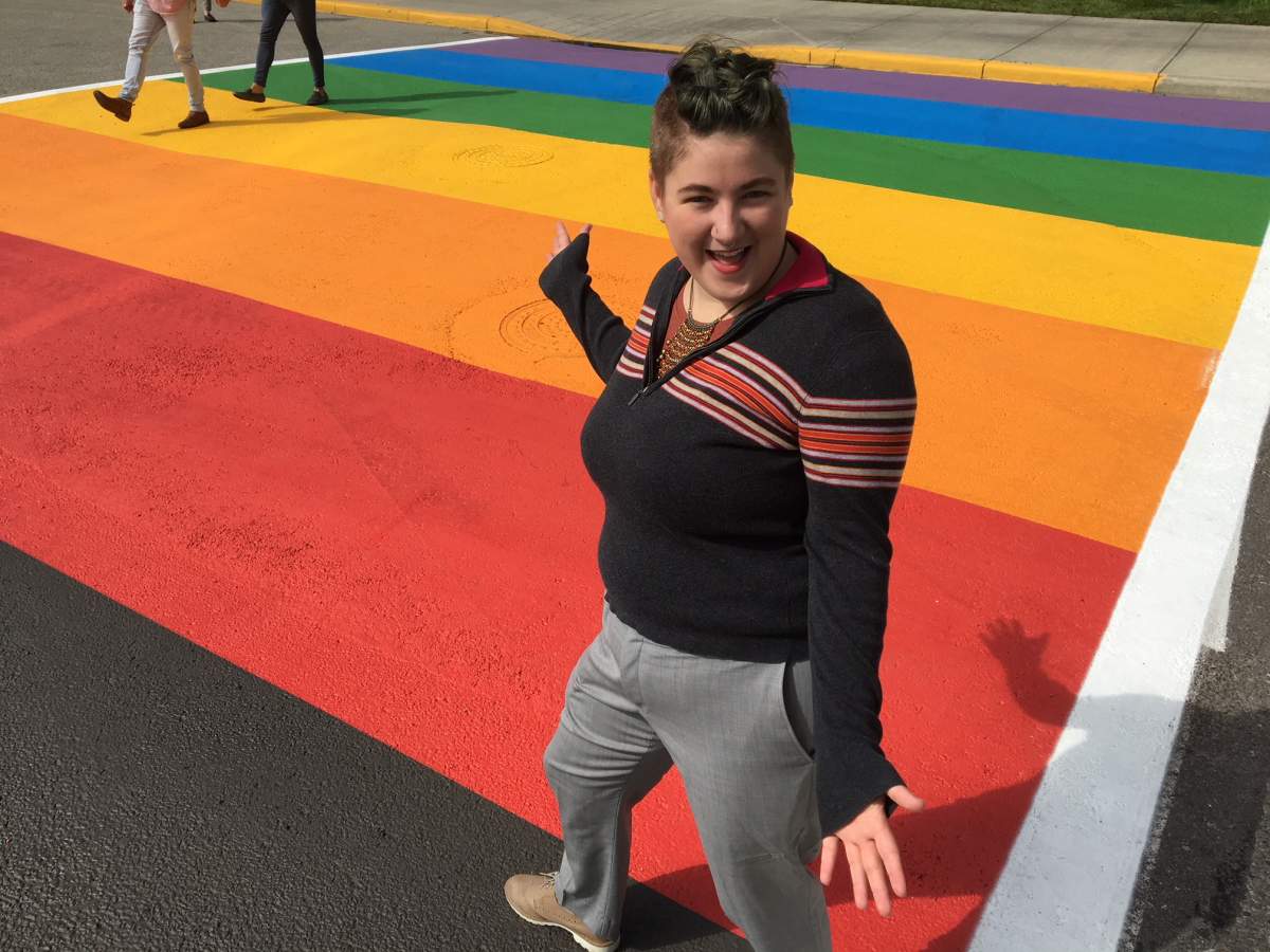MRU student Eddy Robinson stands on the new, permanent rainbow crosswalk on the campus.