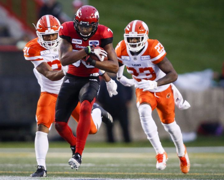 BC Lions' Otha Foster III, left, and Anthony Thompson, right, chase Calgary Stampeders' Kamar Jorden, during second half CFL football action in Calgary, Saturday, Aug. 4, 2018.