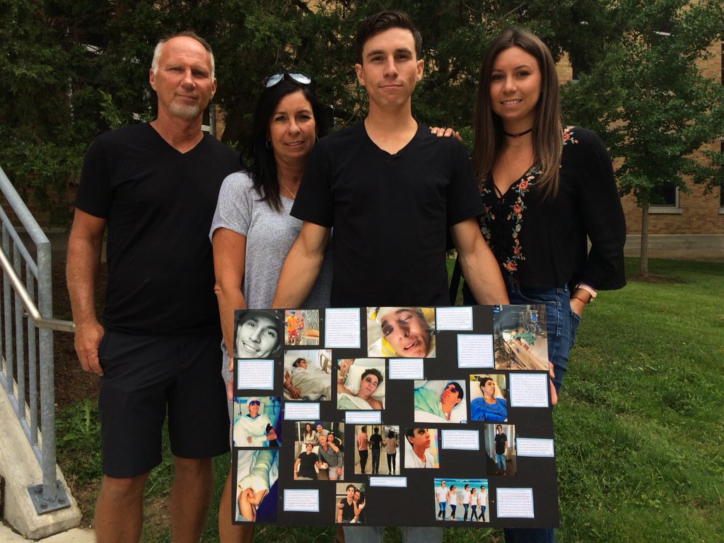 Cole Liley holds up a photographs of his recovery journey. He's joined by his sister Madison (right), his father Jeff (left) and his mother Candice, (second from left.).