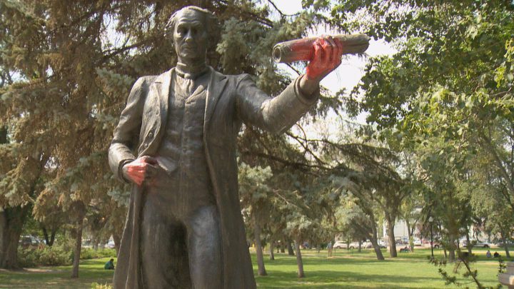 The John A Macdonald statue in Regina's Victoria Park with spray-painted red hands. 