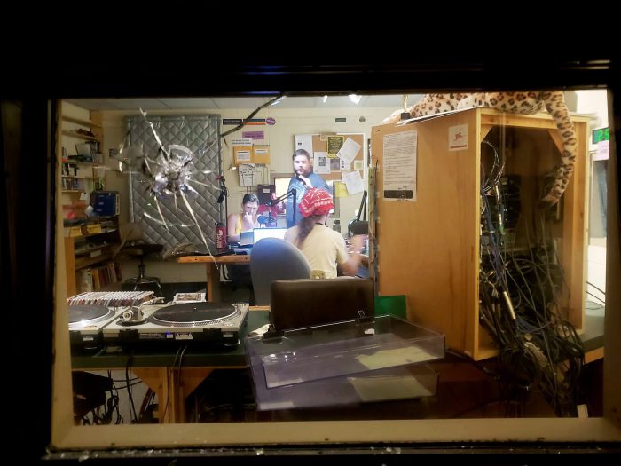 A bullet hole is seen in a studio window at community radio station WORT-FM in Madison, Wis., after an early morning shooting by an intruder left one of the station's disc jockeys with non-life threatening injuries Sunday, Aug. 5, 2018. 