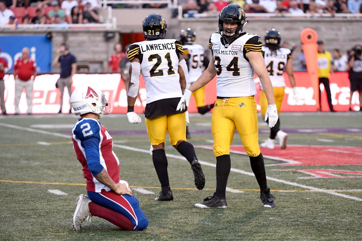 Hamilton Tiger-Cats defensive end Justin Capicciotti (94) and linebacker Simoni Lawrence (21) celebrate a pass interception as Montreal Alouettes quarterback Johnny Manziel (2) looks on during first quarter CFL football action in Montreal on Friday, Aug. 3, 2018.