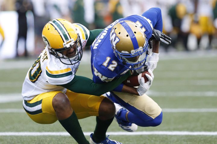 Winnipeg Blue Bombers' Adarius Bowman (12) snags the touchdown pass against Edmonton Eskimos' Maurice McKnight (40) during the first half of pre-season CFL action in Winnipeg Friday, June 1, 2018. 