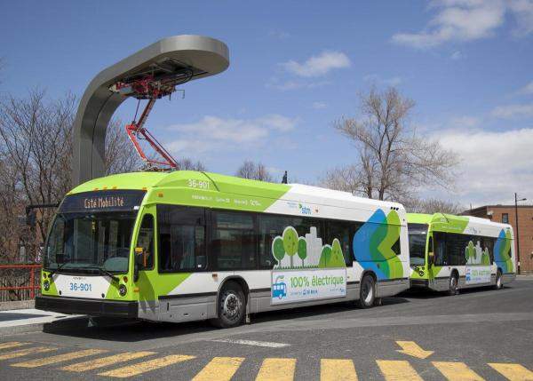 File photo of two quick-charging electric buses operating in Montreal, with a charging station above.