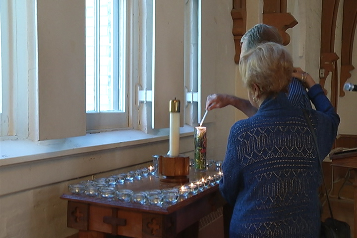 A couple light a candle to honour someone who died as a result of a drug overdose. 
