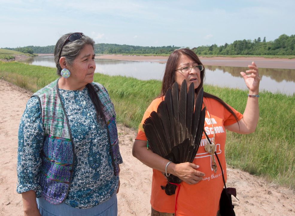 Mi’kmaq activists Dorene Bernard, right, and Ducie Howe stand on the shores of the Shubenacadie River, a 72-kilometre tidal river that cuts through the middle of Nova Scotia and flows into the Bay of Fundy, in Fort Ellis, N.S. on Tuesday, July 31, 2018.