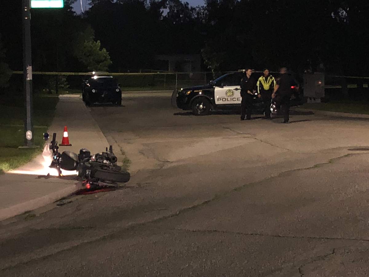 An abandoned motorcycle sits on the side of the road as police investigate a possible shooting on Sunday. 