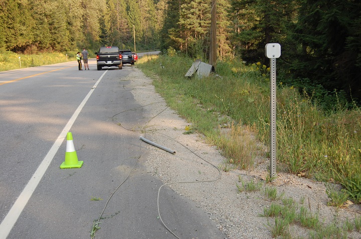 An RCMP officer interviews a witness while remnants of the downed power line incident litter the side of the Trans Canada Highway on Tuesday.