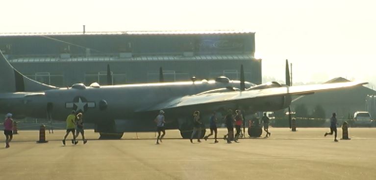Runners pass the B-29 Superfortrress "Fifi' at the Peterborough Airport.