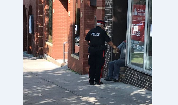 Chris Madsen posted this photo of a Saint John Police Force officer handing a panhandler a Tim Hortons breakfast.