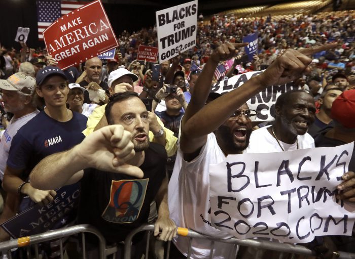 In this Tuesday, July 31, 2018, file photo, supporters of U.S. President Donald Trump shout down a CNN news crew before a rally in Tampa, Fla.