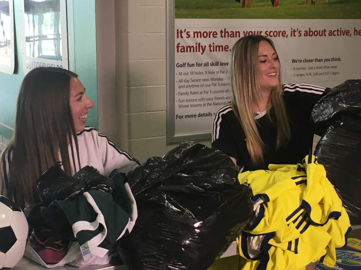 Samantha Adams and Darby Spence sort donated soccer gear at the Calgary Soccer Centre on Aug. 8, 2018.