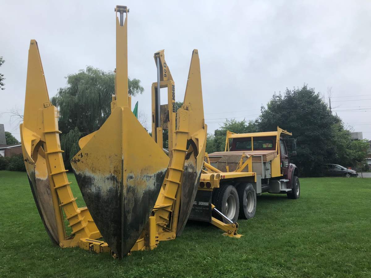 Uprooting and replanting trees requires a spade truck. The truck's large spades, which resemble a claw. encircle the tree, plunge into the soil, and lift up the entire tree and its roots.