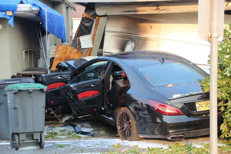 Black luxury car goes up in flames after crashing into Surrey garage - image