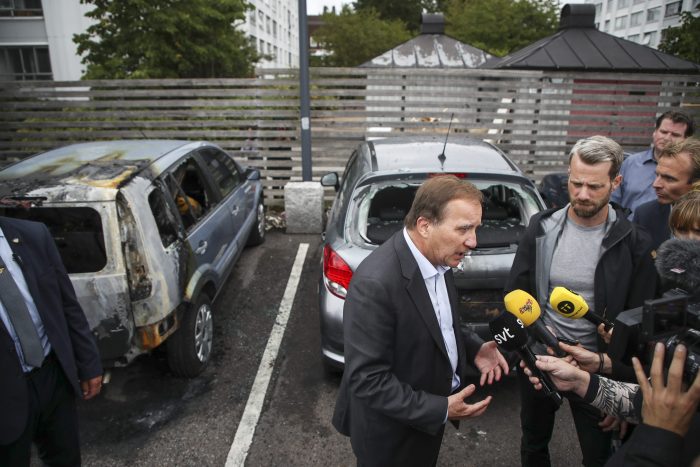 Swedish Prime Minister Stefan Lofven (centre) talks to journalists after meeting with local police at Frolunda torg in Gothenburg, Sweden, on Aug. 14, 2018.