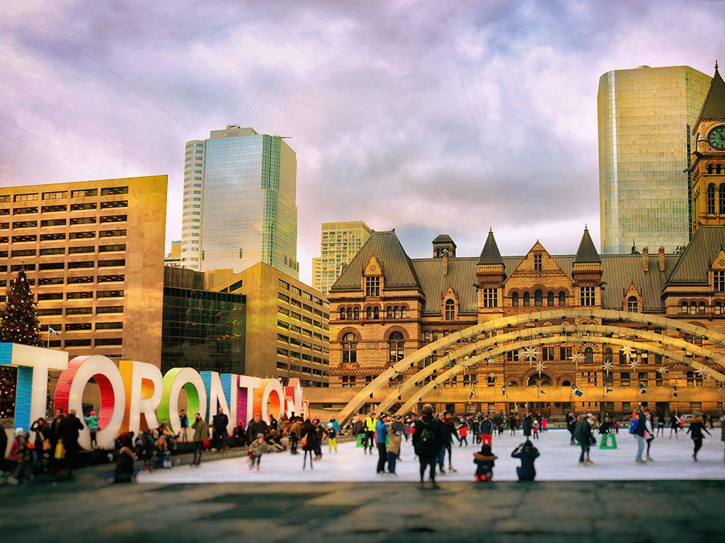 Lots of people are having fun by the colourful Toronto sign at Nathan Phillips Square.