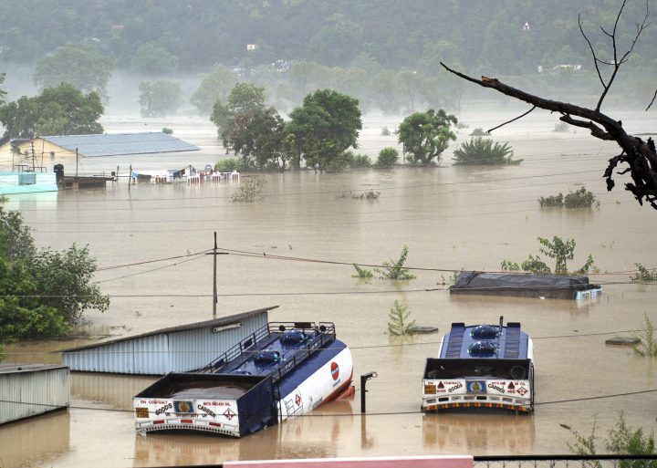 Houses are submerged as trucks flow in flood waters of the Bhagirathi River in Shrinagar district in northern Indian state of Uttarakhand, India, Monday, June 17, 2013.