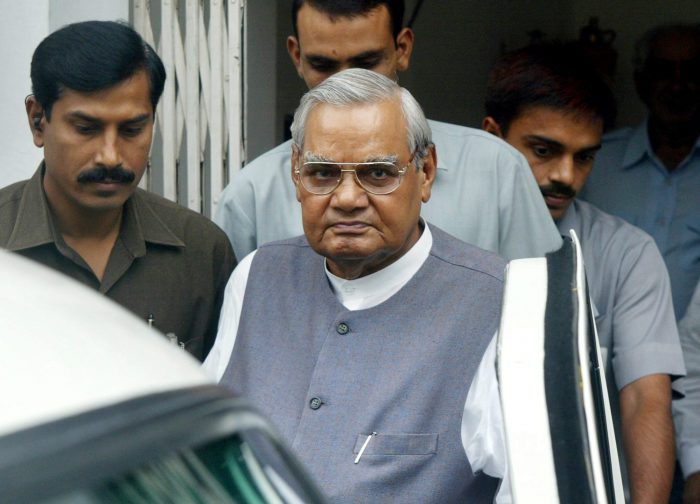 In this Aug. 23, 2004 file photo, senior Bharatiya Janta Party leader Atal Bihari Vajpayee, centre, leaves after a meeting at the party headquarters in New Delhi, India.  