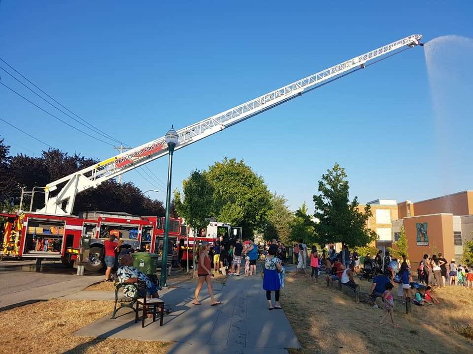 Firefighters spray crowds at a pop-up water park on Thursday, Aug. 10.
