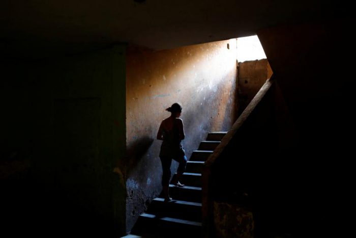 Elizabeth Altuve climbs the stairs at the occupied building where she lives in Maracaibo, July 26, 2018. 