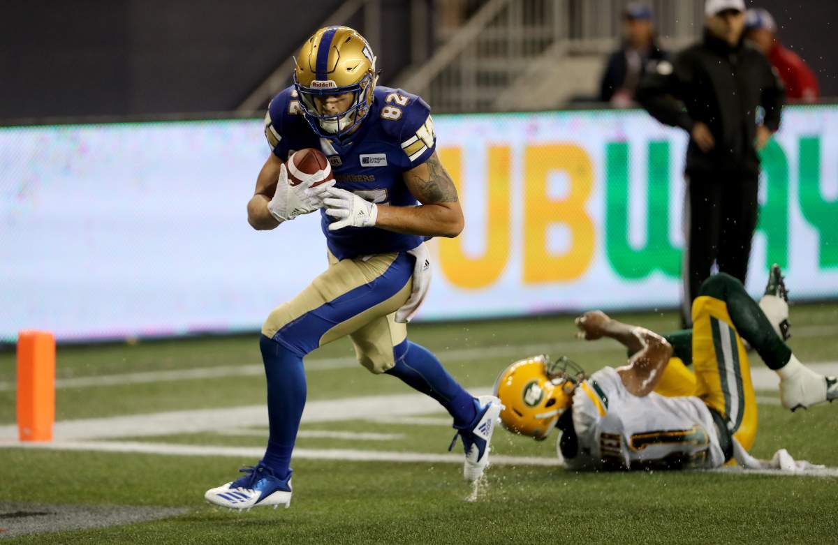Winnipeg Blue Bombers’ Drew Wolitarsky (82) breaks a tackle by Edmonton Eskimos’ Hunter Monshadrik (41) to score a touchdown during third quarter CFL action against the Winnipeg Blue Bombers’ in Winnipeg on Thursday, June 14, 2018. (CFL PHOTO – Trevor Hagan)