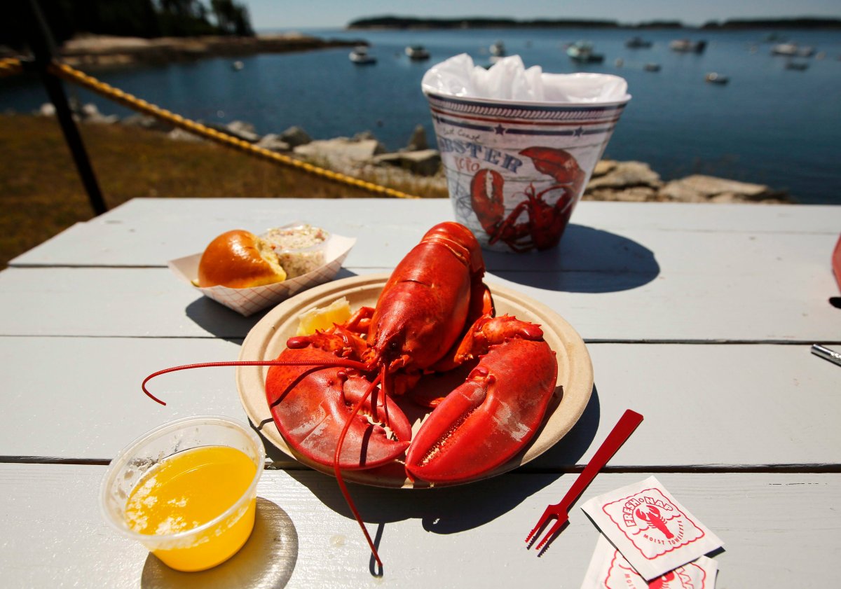 IIn this Thursday, July 19, 2018 photo, a cooked lobster is served on a picnic table at McLoon's Lobster Shack in Spruce Head, Maine.