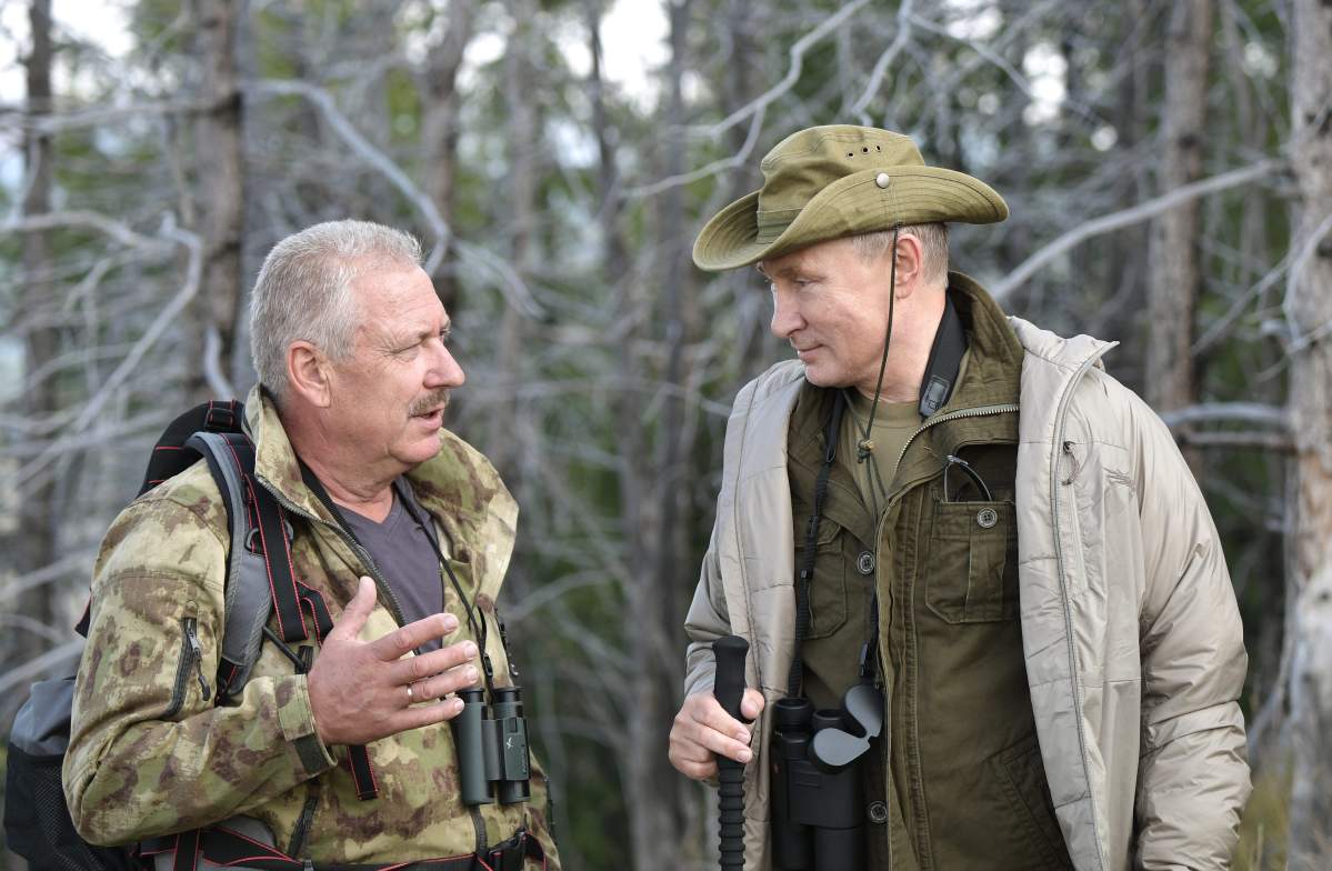 A picture made available on Aug. 27, 2018, shows Russian President Vladimir Putin (R) speaking with the Director of the Sayano-Shushenskiy State Biospheric Nature Reserve, Gennady Kiselev (L), during his vacation in the Republic of Tuva, in southern Siberia.