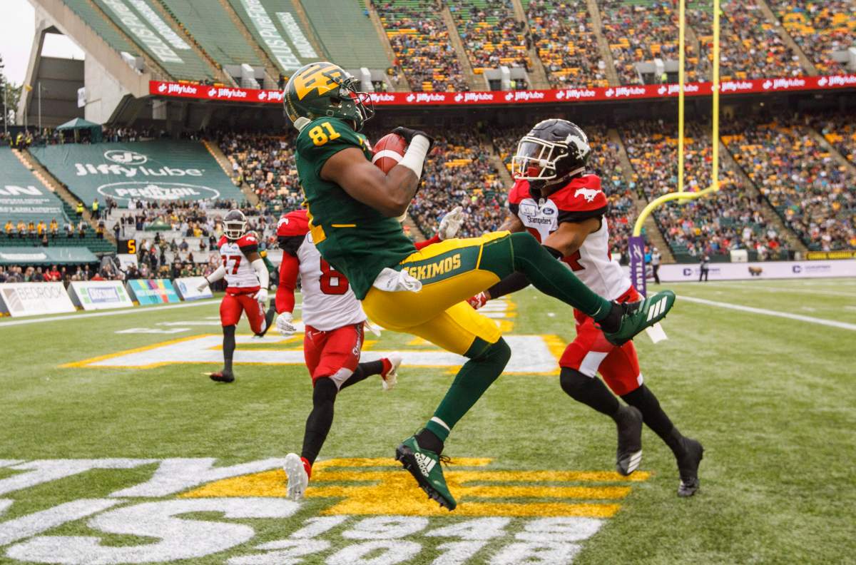 Calgary Stampeders Tay Glover-Wright (24) and Emanuel Davis (8) try to stop Edmonton Eskimos D’haquille Williams (81) as he scores a touchdown during first half CFL action in Edmonton, Alta., on Saturday September 8, 2018. THE CANADIAN PRESS/Jason Franson.