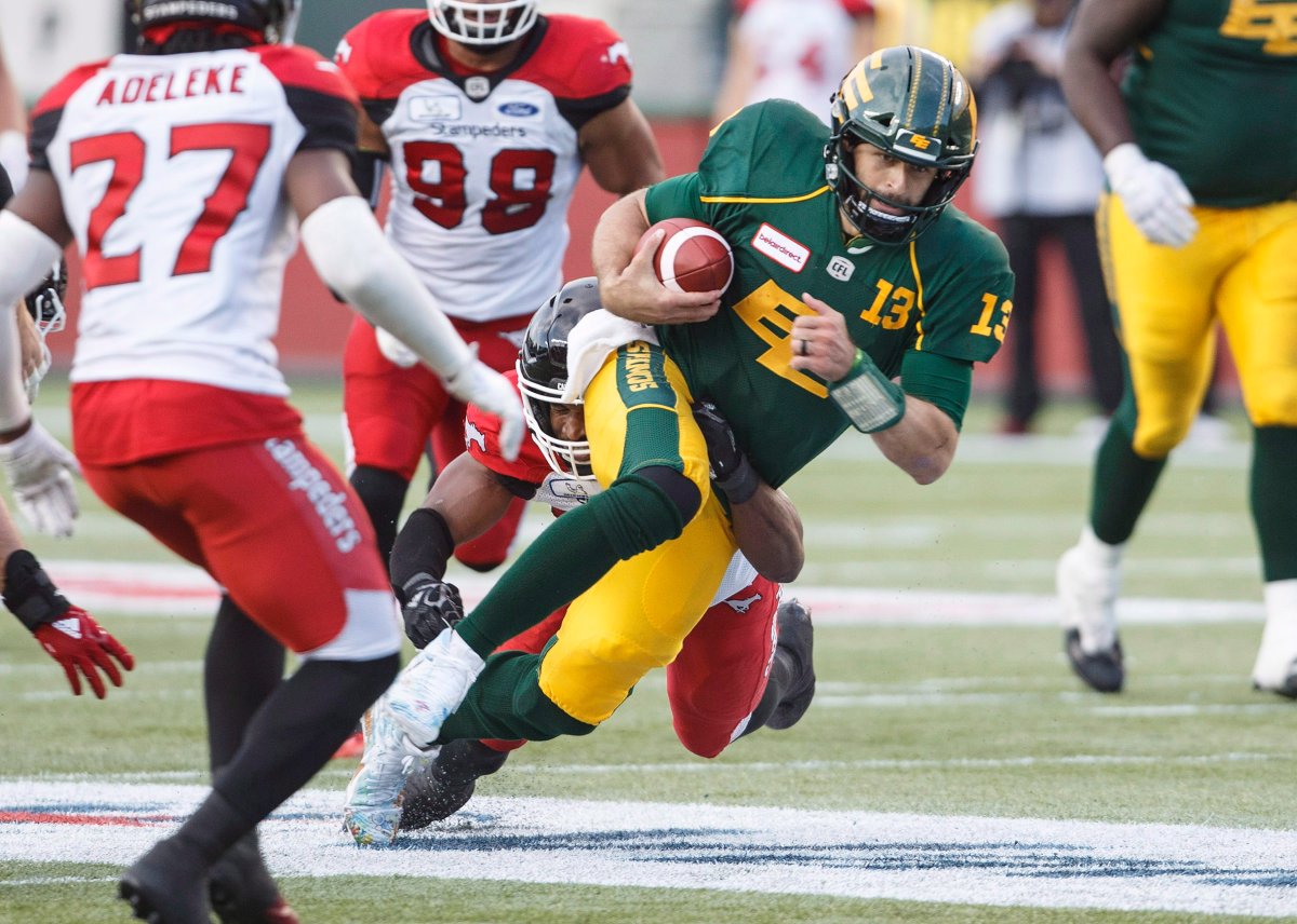 Edmonton Eskimos quarterback Mike Reilly (13) runs the b all against the Calgary Stampeders during first half CFL action in Edmonton, Alta., on Saturday September 8, 2018.