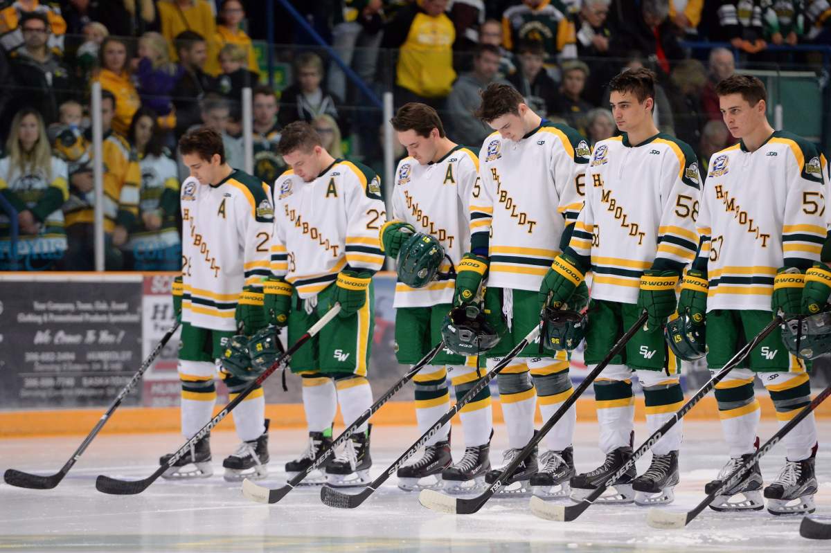 Returning Humboldt Broncos players Brayden Camrud (26) and Derek Patter (23), far left, along with other teammates take part in a moment of silence during a pregame ceremony before playing the Nipawin Hawks in the SJHL season home opener Wednesday, Sept. 12, 2018. THE CANADIAN PRESS/Jonathan Hayward