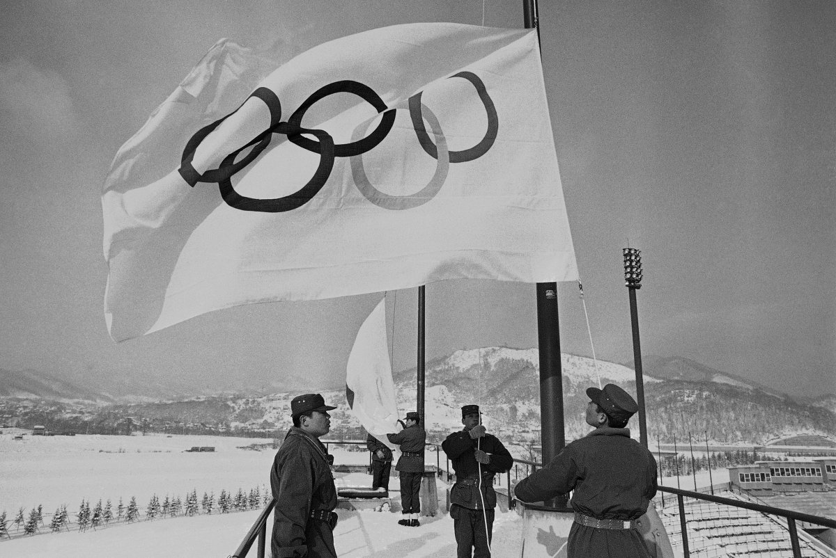 In this Jan. 23, 1972, file photo, members of Japan's self-defense ground forces raise Olympic Flags in Sapporo at Makomanai speed skating stadium in a rehearsal of ceremony at the official opening of Winter Olympics. 