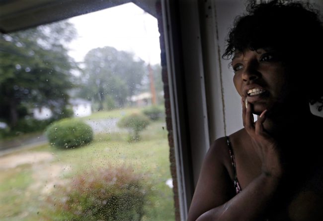 Nichole Worley looks out from her home in Lumberton, N.C., Friday, Sept. 14, 2018, as rains from Hurricane Florence threaten the neighborhood with flooding.