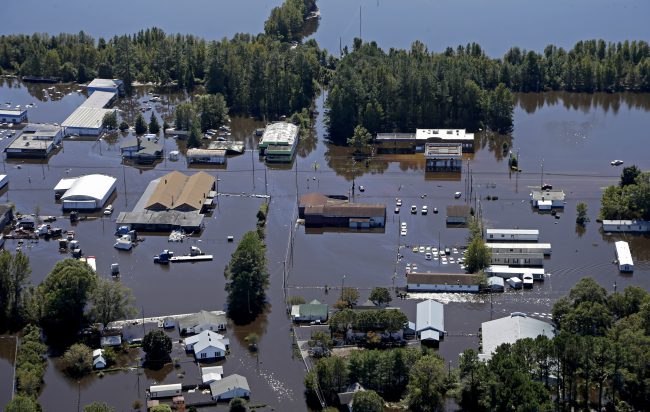 In this Oct. 12, 2016, file photo, homes and businesses are surrounded by floodwaters from Hurricane Matthew in Lumberton, N.C.