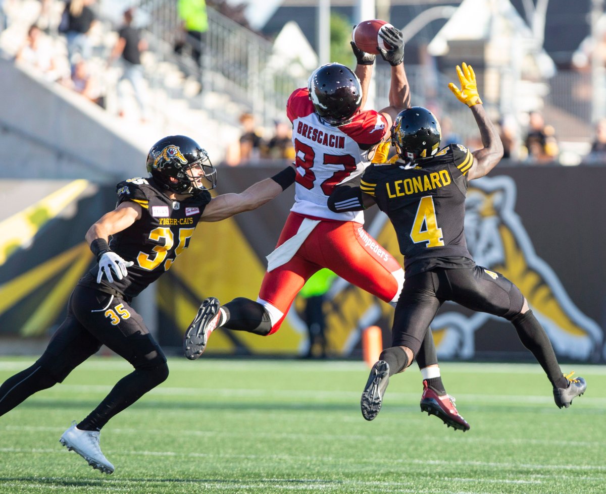 Calgary Stampeders wide receiver Juwan Brescacin (82) makes the catch as Hamilton Tiger-Cats defensive back Mike Daly (35) and Richard Leonard (4) defend during first half CFL Football game action in Hamilton, Ontario on Saturday, September 15, 2018. 