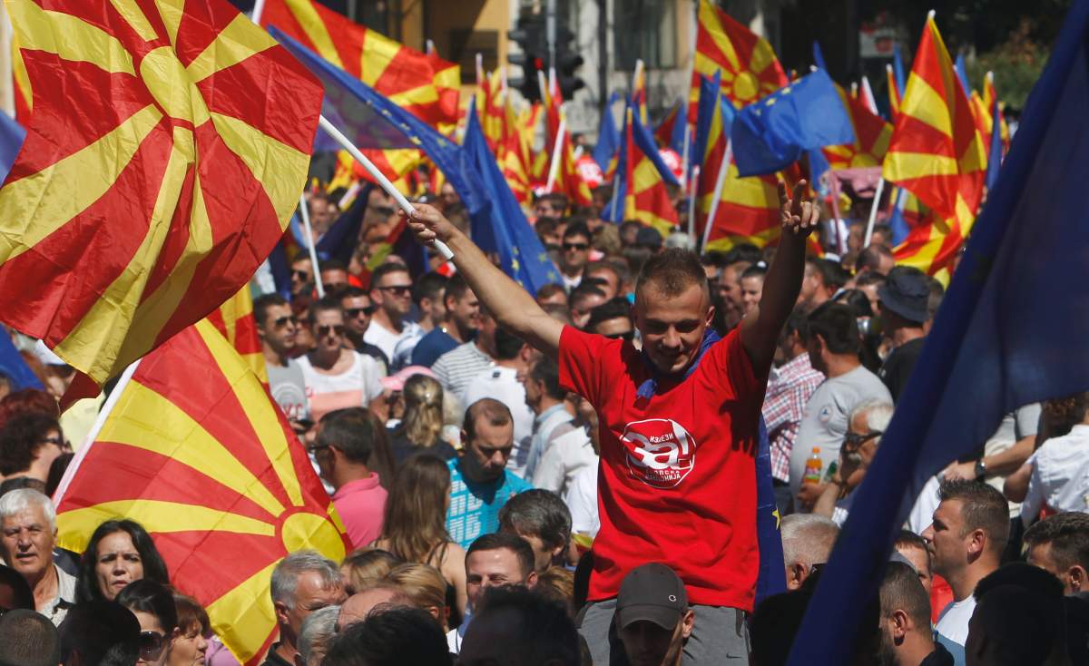 People waving Macedonian and EU flags take part in a march named "For European Macedonia", in downtown Skopje, Macedonia, Sunday, Sept. 16, 2018.