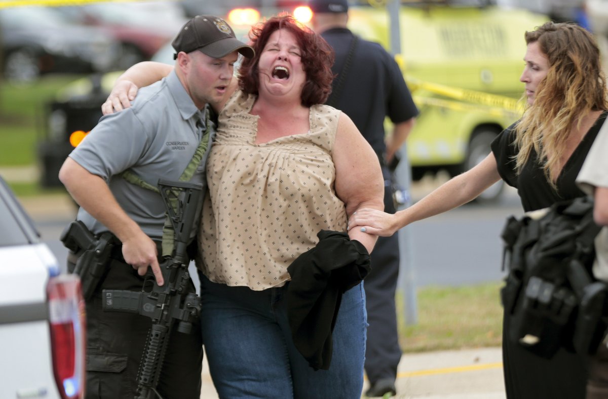 A woman is escorted from the scene of a shooting at a software company in Middleton, Wis., Wednesday, Sept. 19, 2018.     