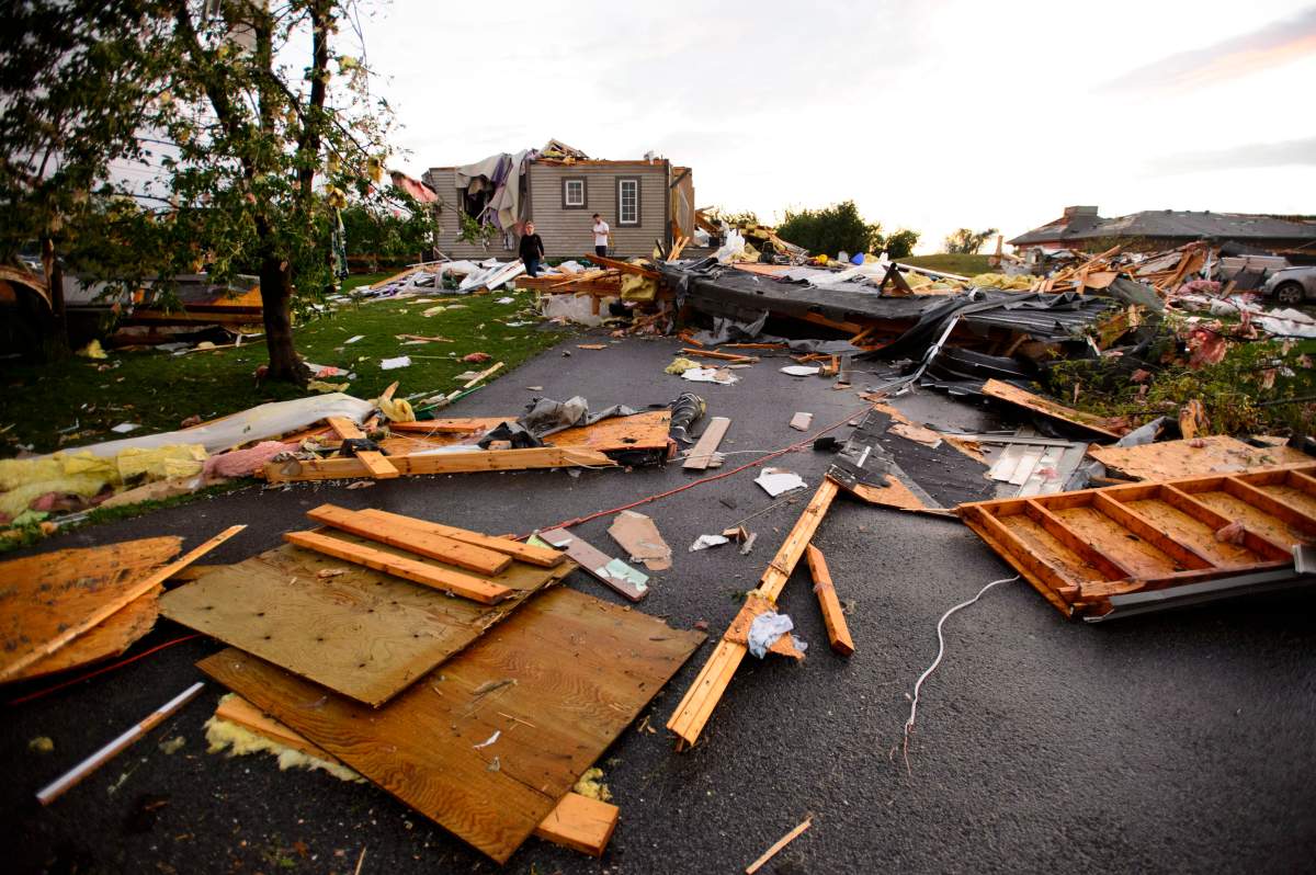 A young couple surveys the damage to their home following a tornado in Dunrobin, Ontario west of Ottawa on Friday, Sept. 21, 2018.